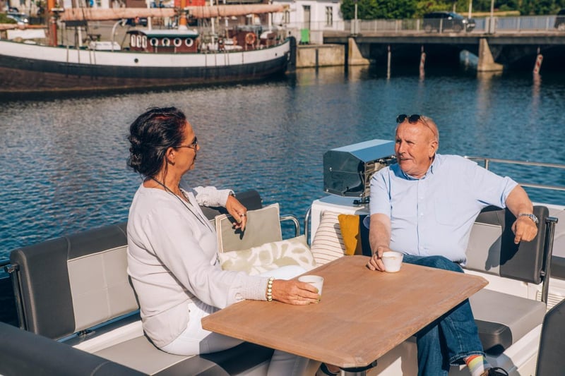 Flybridge-retkivene Delphia 12 FlyLounge liikkeessä järvimaisemassa – hiljainen ja vakaa kulku tuo rauhan tunteen.