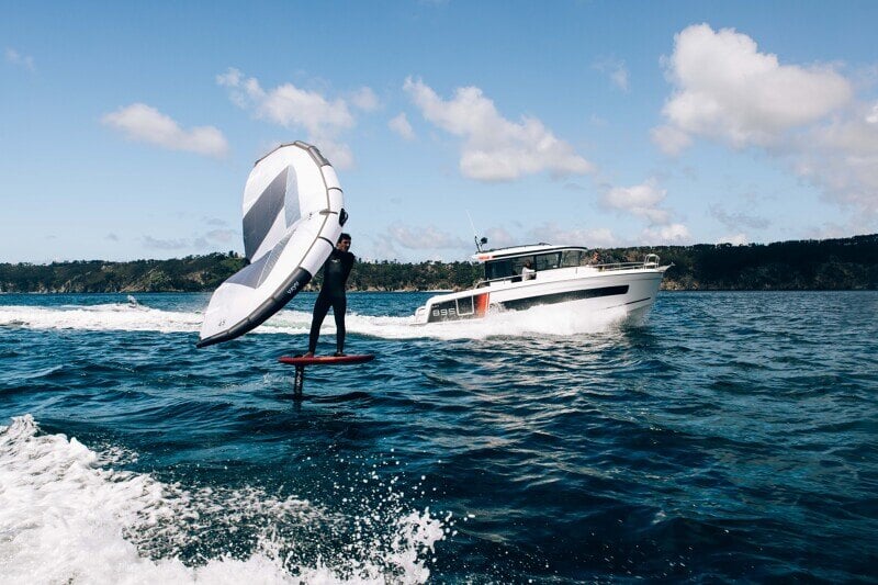 Vesiurheilua täydellä teholla – Wakeboardaaja hyppää veneen aallon yli.