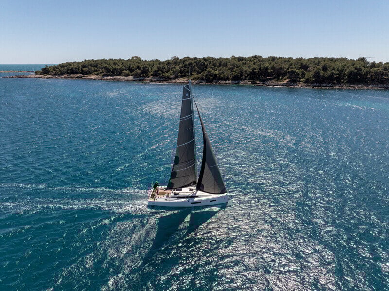 Sun Odyssey 350 purjehtimassa avomerellä, sen moderni runko ja purjeet täydessä toiminnassa.