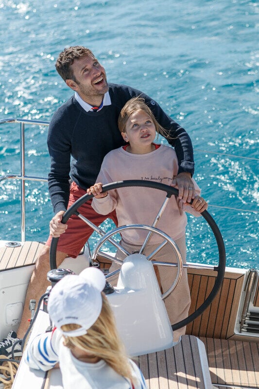 Sun Odyssey 350:n avotila, jossa on kaksinkertaiset ohjauspyörät ja suuri ruokailupöytä.