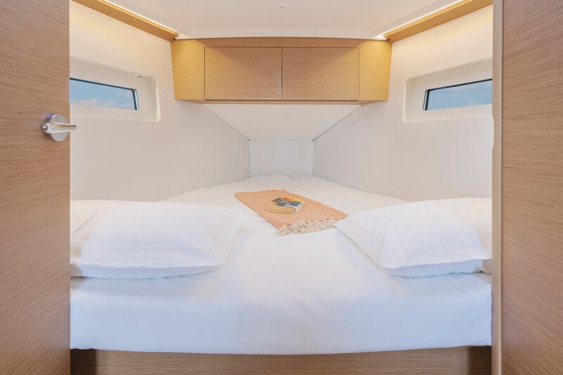 Keulakajuutta Sun Odyssey 350:ssä, jossa tilava sänky ja luonnonvaloa tuovat ikkunat.