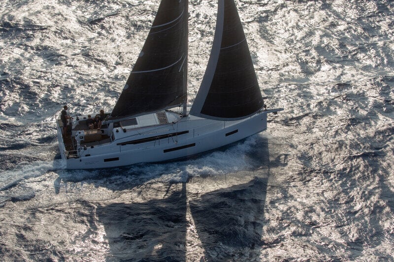 Sun Odyssey 410 yläviistosta – Ilmakuva veneestä purjeet ylhäällä, esitellen sen tasapainoista muotoilua.