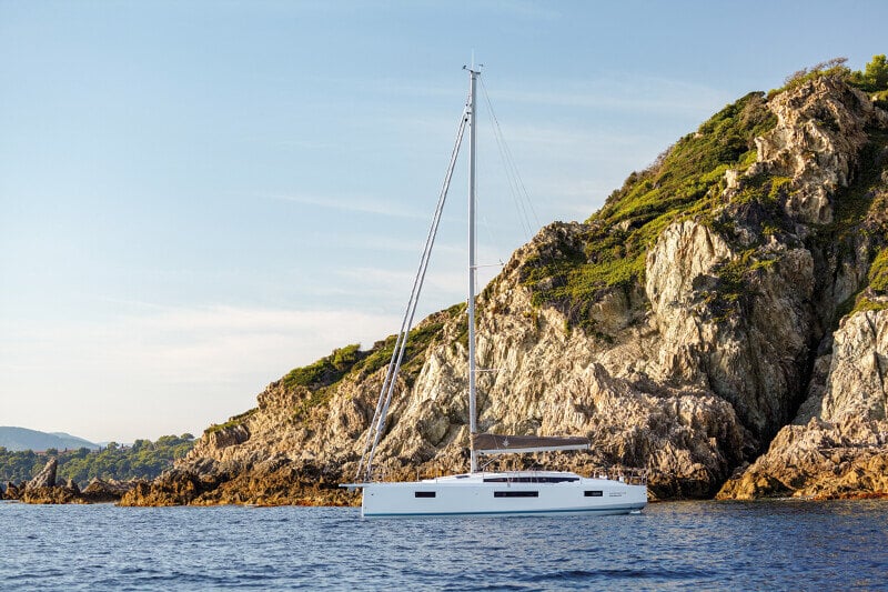 Sun Odyssey 410 liikkeessä – Vene purjehtimassa dynaamisesti aalloilla, kuvaten sen suorituskykyä.