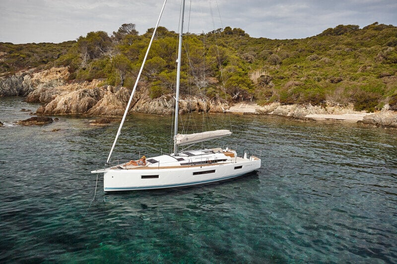 Sun Odyssey 440 ankkurissa rauhallisessa lahdessa, ympärillä kristallinkirkas vesi.