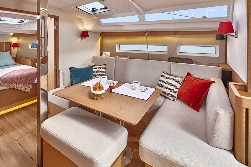 Sun Odyssey 440:n salonki, jossa suuri ruokapöytä ja pehmeät sohvat takaavat mukavan oleskelun.