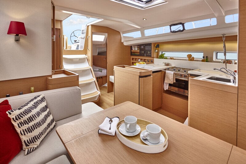  Sun Odyssey 440:n salonki, jossa suuri ruokapöytä ja pehmeät sohvat takaavat mukavan oleskelun.