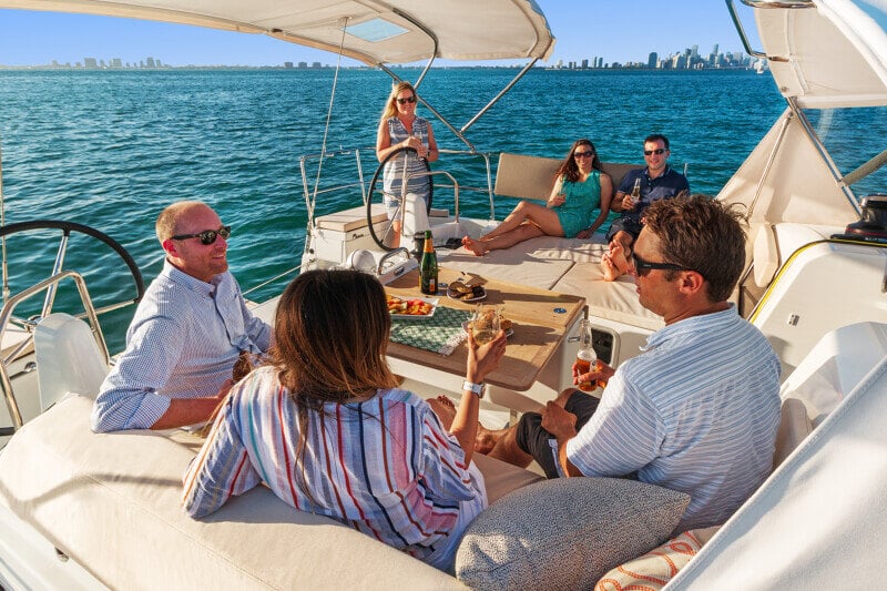 Sun Odyssey 490 - ystäväporukka nauttimassa illallisesta veneen kannella luonnon helmassa.