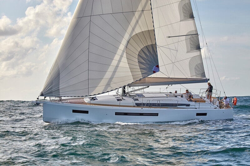 Sun Odyssey 490 - näyttävä sivuprofiili, jossa vene liukuu sulavasti meren aalloilla auringonpaisteessa.