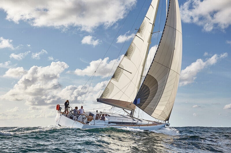 Sun Odyssey 490 - purjevene kovassa vauhdissa, purjeet täydessä vedossa ja miehistö hallitsemassa venettä.