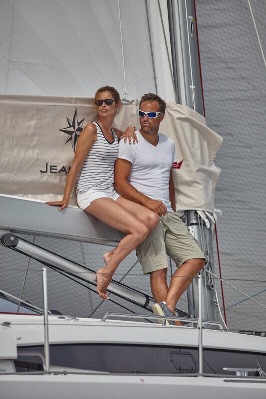 Sun Odyssey 490 - pariskunta nauttimassa yhdessäolosta purjeveneen kannella Jeanneau-logon edessä.