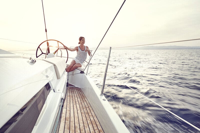 Sun Odyssey 490 - Nainen purjehtii auringon laskussa