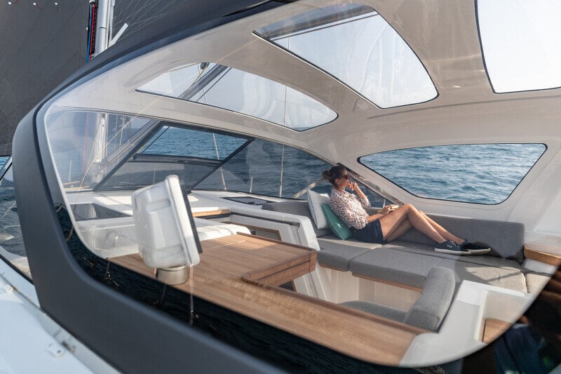 Nainen rentoutuu Jeanneau Yachts 55:n tilavassa peräkannen lounge-tilassa, jossa mukavat istuimet ja merinäköala korostuvat.