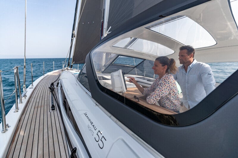 Mies ja nainen viettävät aikaa Jeanneau Yachts 55:n sisätiloissa, joissa yhdistyvät tyylikkyys ja käytännöllisyys.
