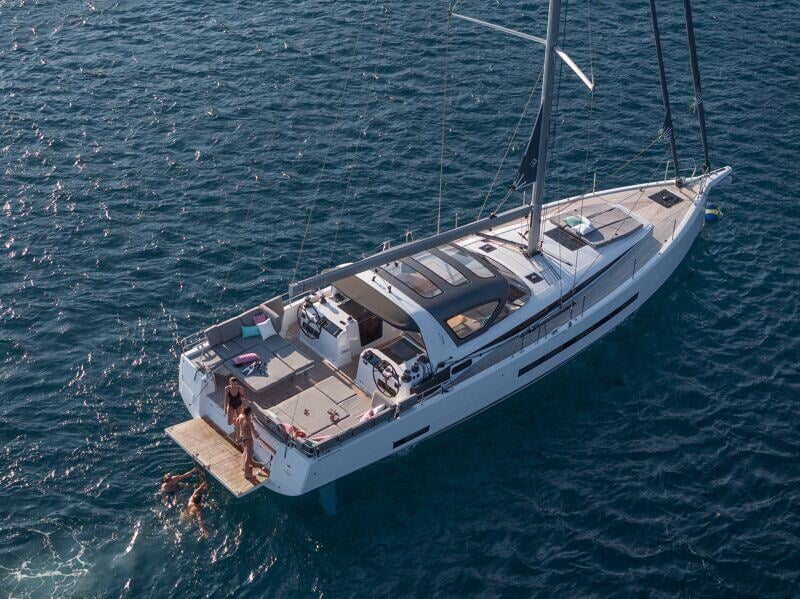 Ilmakuva Jeanneau Yachts 55:stä purjehtimassa avomerellä upean luonnon keskellä.