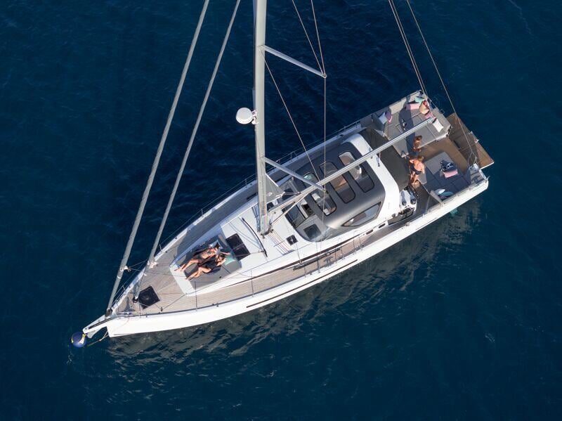 Ilmakuva Jeanneau Yachts 55:stä liitämässä avomerellä, jossa sen suuret purjeet ja virtaviivainen runko korostavat veneen suorituskykyä.