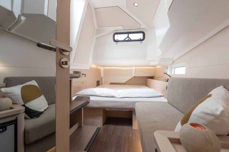 Jeanneau Yachts 55:n vierashytti, jossa viihtyisä parisänky, pehmeät tyynyt ja elegantti sisustus.