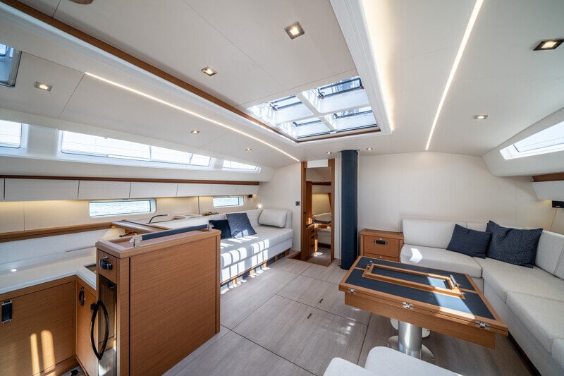 Jeanneau Yachts 65 -veneen salonki iltavalaistuksessa, lämmin ja tunnelmallinen.