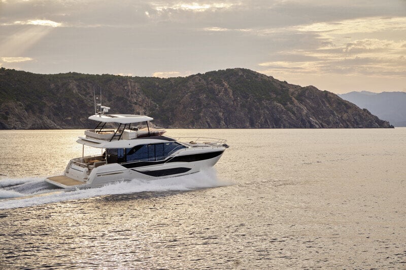 Night cruise of the Prestige F5.7, its deck lights illuminating the sea.