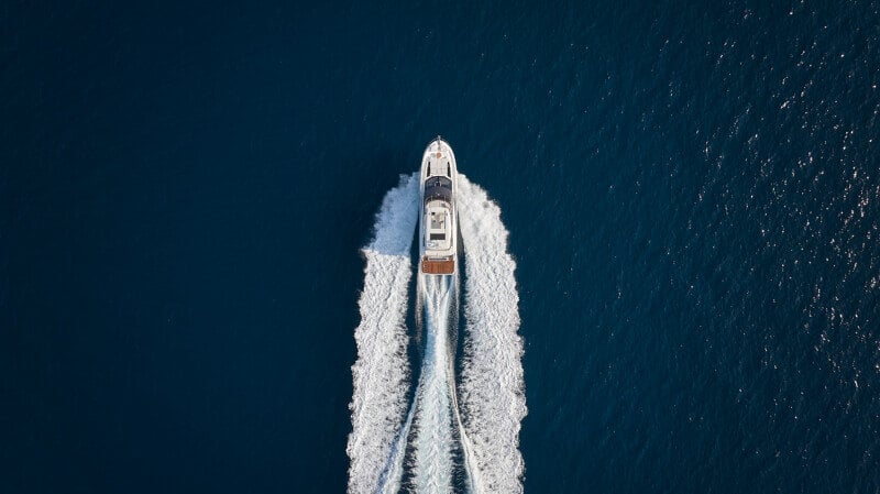 Top-down view of the flybridge featuring a sunbed and a stylish helm station.